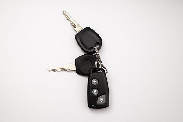 A Set Of Car Keys And A Remote Control On A White Background.