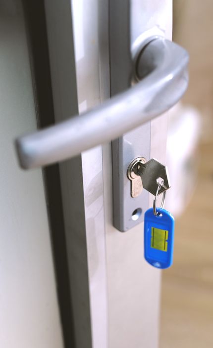 A Key Is Inside A Lock Of A Vehicle's Door.