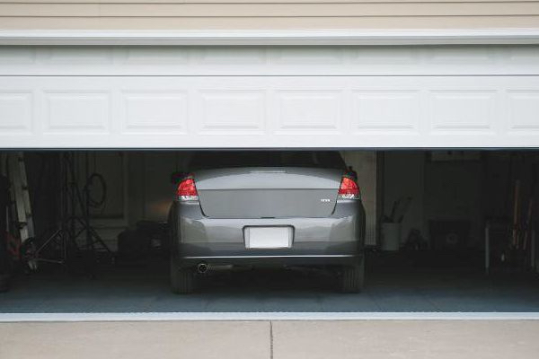 A Car Is Parked In A Garage With The Door Open.