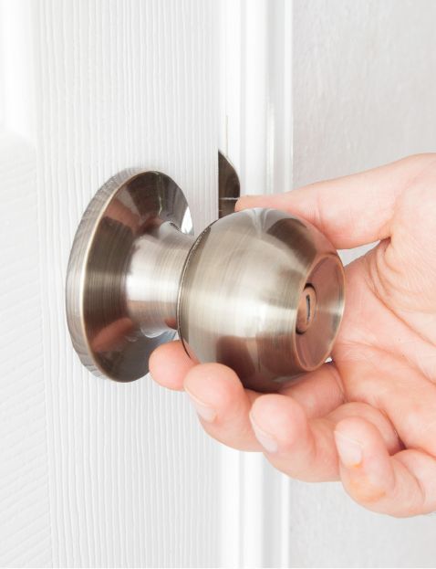 A Locksmith Is Holding A Door Knob In His Hand.